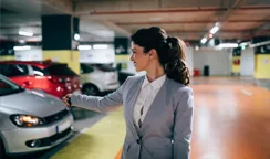 Businesswoman unlocking her car in a well managed parking facility